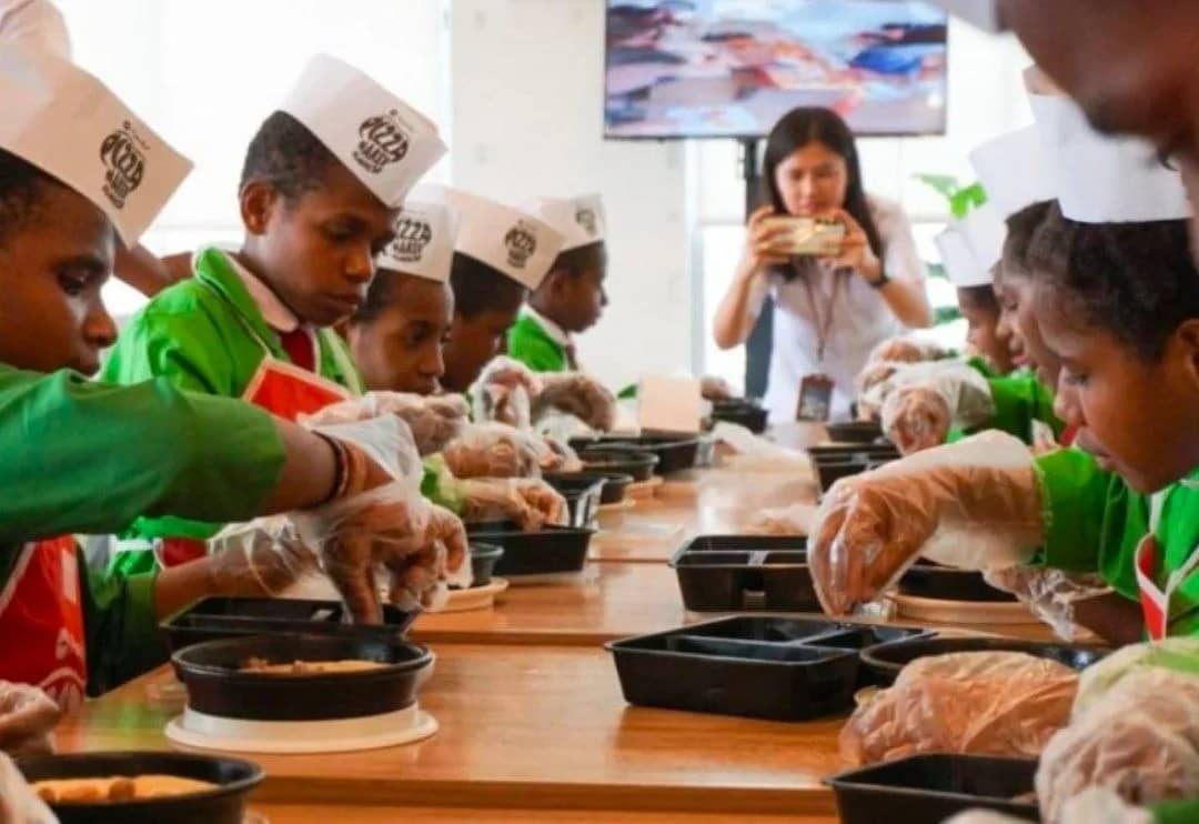 Murid SD SATP memberikan toping pada pizza yang dibuat dalam field trip edukasi di Pizza Hut Cabang Timika