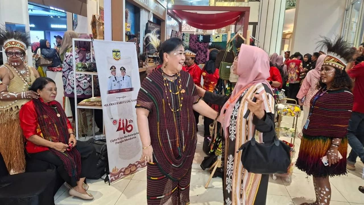 Ketua Dekranasda Kabupaten Mimika, Ny Suzy Rettob saat menerima seorang pejabat di stand pameran UMKM Mimika.