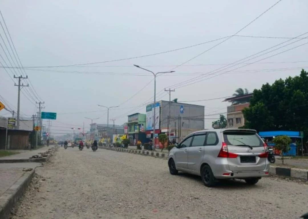 Ruas jalan di lampu lalu lintas  Jalan Hasanudin menuju Pasar Sentra Timika, Papua Tengah mengalami penurunan badan jalan yang sedang dalam proses perbaikan