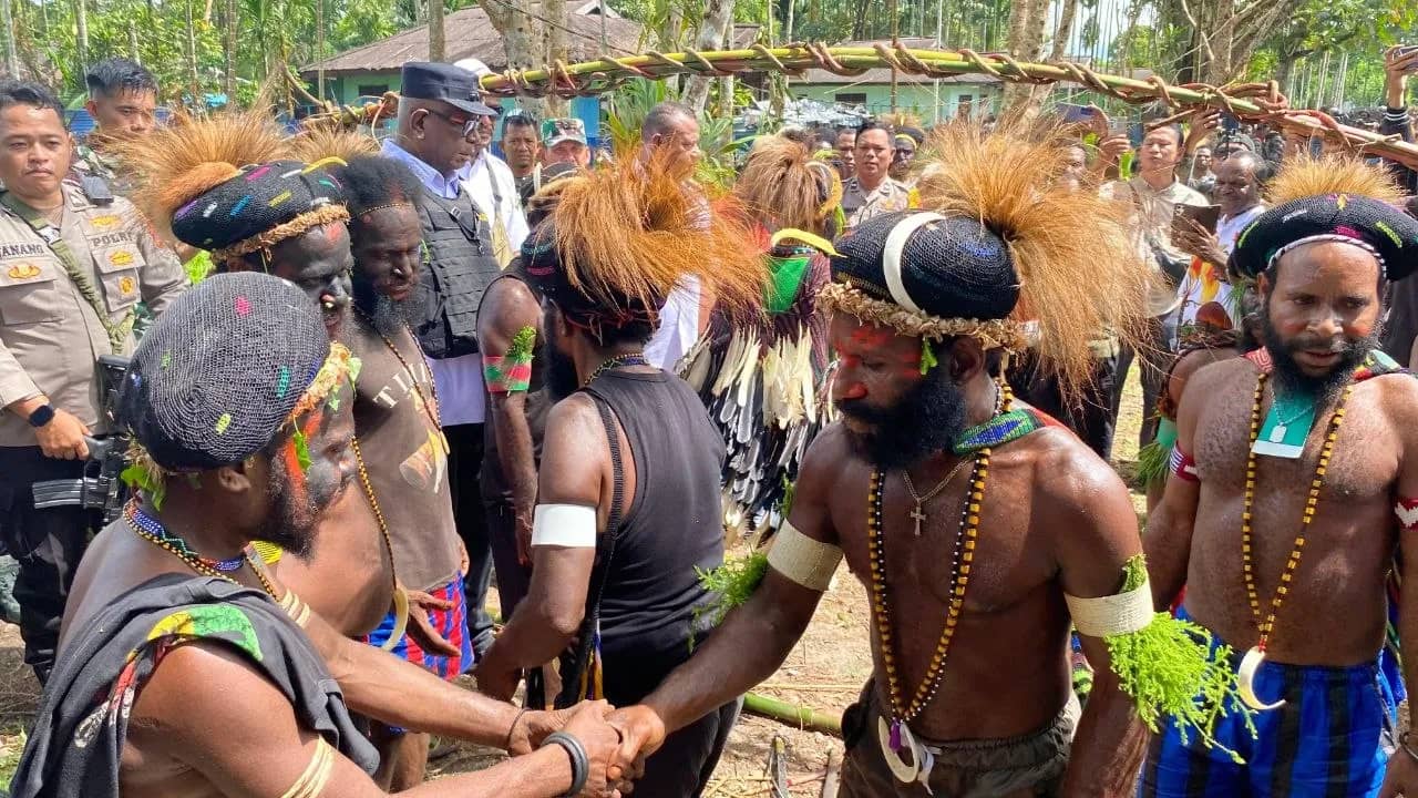 Kedua belah pihak berjabat tangan usai prosesi adat perdamaian di Kampung Amole, Distrik Kwamki Narama, Rabu (24/6/2026).