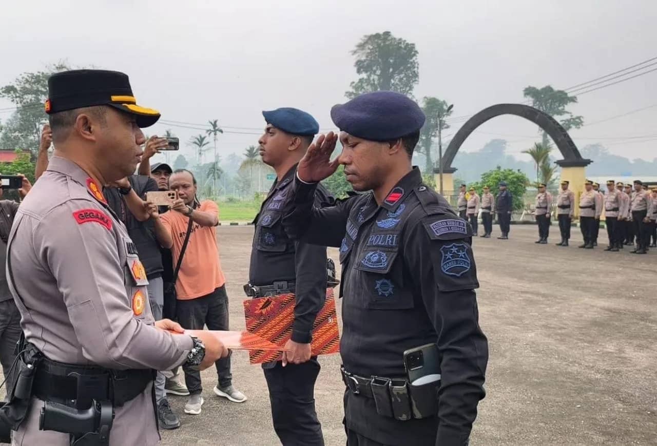 Kapolres Mimika AKBP Alredo Rumbiak menyerahkan penghargaan kepada dua personel Brimob dalam upacara di Mako Polres Mimika, Mile 32, Jumat (9/10).