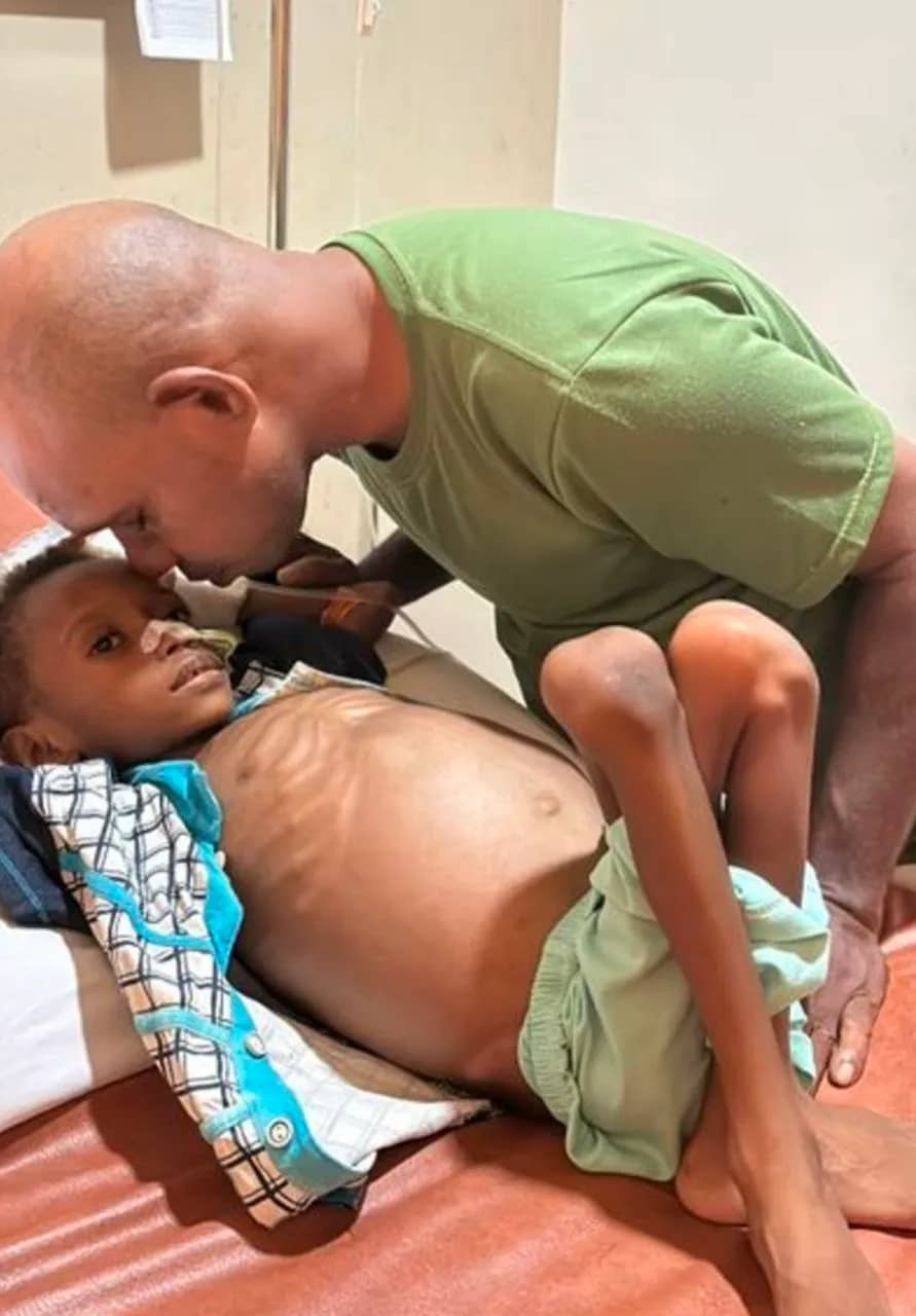 Michael, bocah berusia empat tahun yang hanya bisa menangis sambil memeluk ayahnya, berharap rasa sakitnya sembuh.
