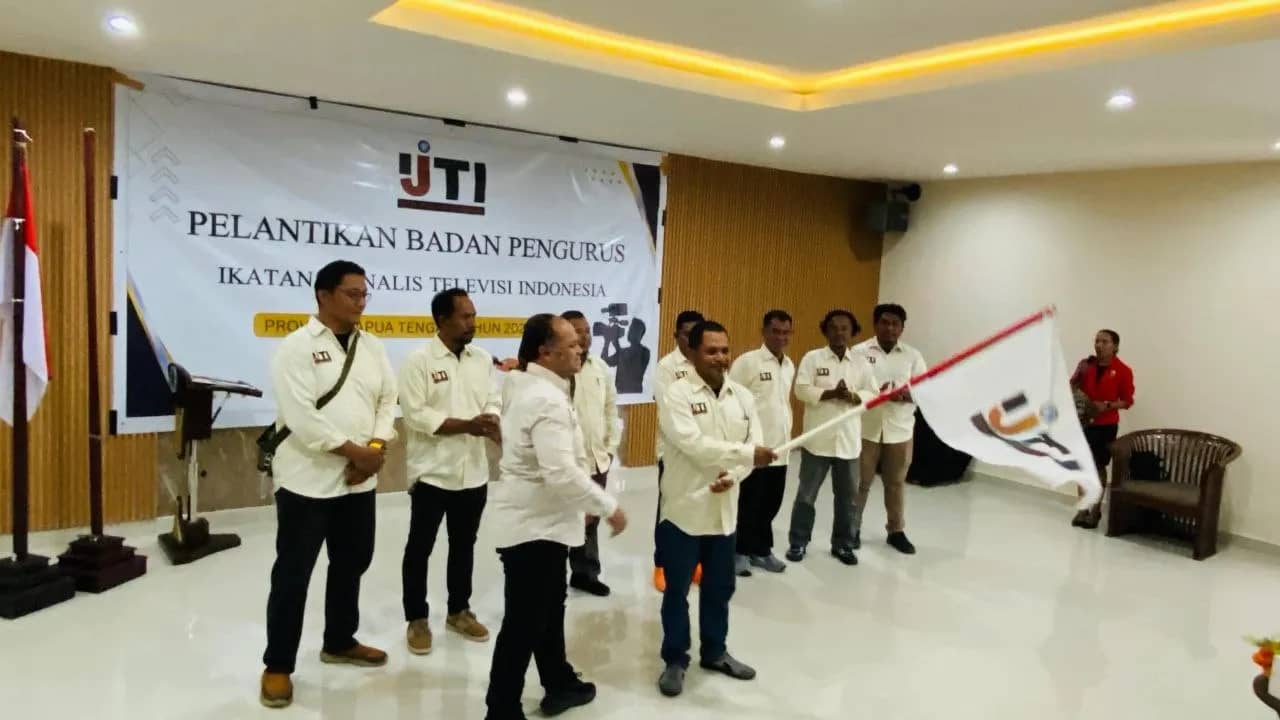 Ketua IJTI Papua Tengah, Desius Termas, menerima bendera IJTI dari Ketua Umum IJTI, Herik Kurniawan, usai pelantikan, Jumat (26/6).