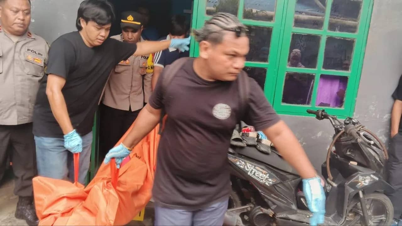 Polisi saat mengevakuasi jenazah korban.