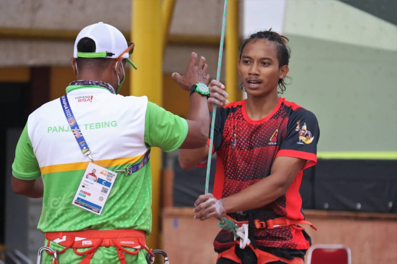 KETERANGAN FOTO : 1.Ravianto Ramadhan, atlet panjat tebing Papua yang berhasil menyumbang emas PON XX dalam final nomor Lead kategori Perorangan Putra di Venue Sport Climbing Kabupaten Mimika, Selasa (05/10/2021)/ Foto: Saldi Hermanto/Humas PPM 2. Atlet panjat tebing Papua, Ravianto Ramadhan menyabet emas di kelas lead putra PON XX Papua di venue panjat tebing Mimika, Selasa (5/10/2021). Foto: Humas PPM/ David La'/lang