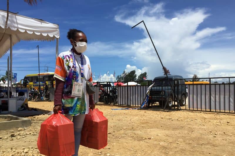 Tevina Leberina Ayomi mengangkut konsumsi saat bertugas di arena dayung di Teluk Youtefa, Jayapura, Senin (4/10/2021)