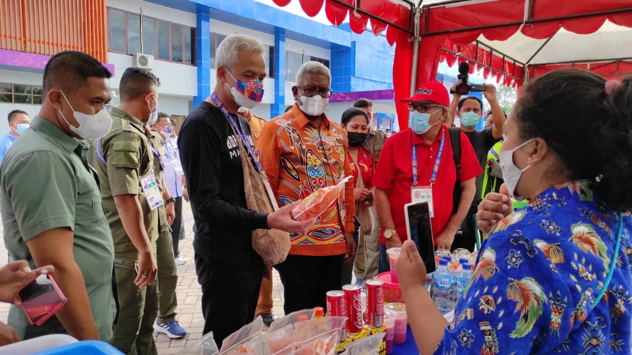 Gubernur Jawa Tengah, Ganjar Pranowo dan Wakil Bupati Mimika, Johannes Rettob saat berbincang dengan penjual ole-ole Papua.