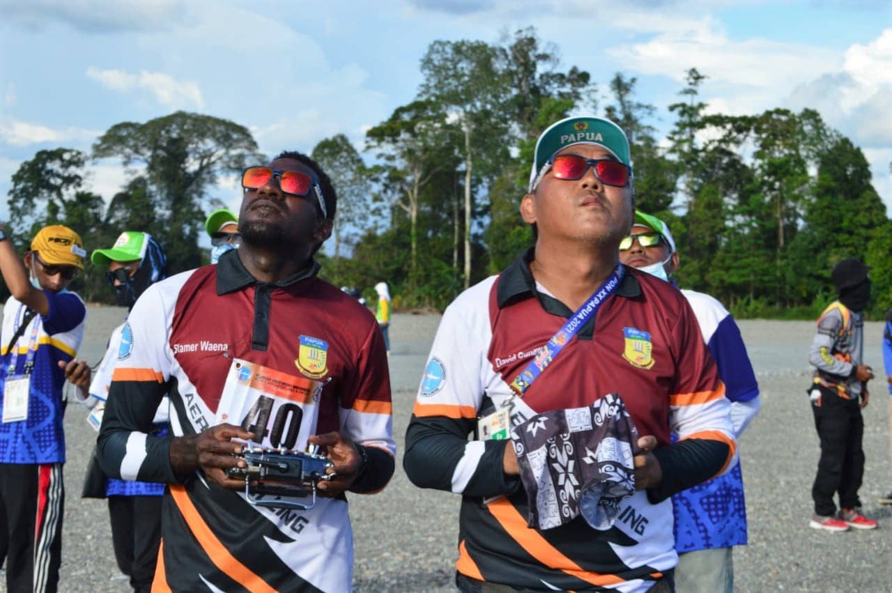 Atlit Aeromodeling Papua, Sefnat Marnian (kiri) bersama pelatihnya David Gunawan (kanan) saat mengontrol pesawat miniaturnya dalam pertandingan Final Aeromodeling F3J INA di Venue Aeromodeling SP-5 Timika, Rabu (6/10/2021). (Foto: Lukas Tandilimbong/Humas PPM)