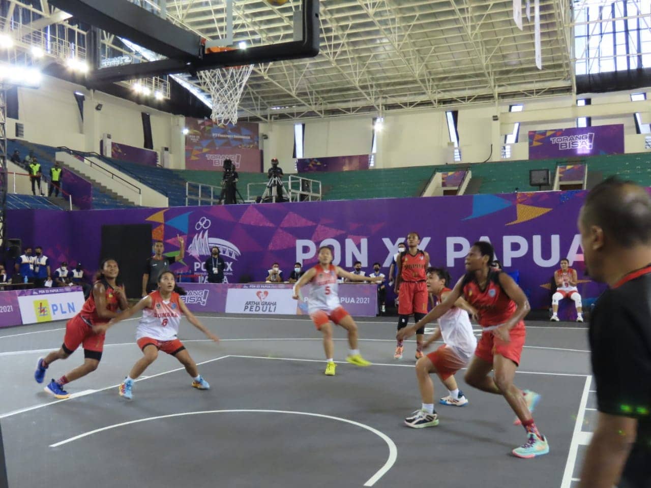 Pertandingan Basket 3x3 antara Tim Basket Putri Papua (Kostum merah) mengalahkan Tim Sumatera Barat (Kostum putih oranye), skor 10 - 21, bagi kemenangan Putri Cenderawasih, dalam laga penyisihan Cabor Basket 3x3putri di Venue Basket Mimika Sport Complex, Selasa sore (12/10/2021). Foto: Humas PPM/ Victory Tobias.