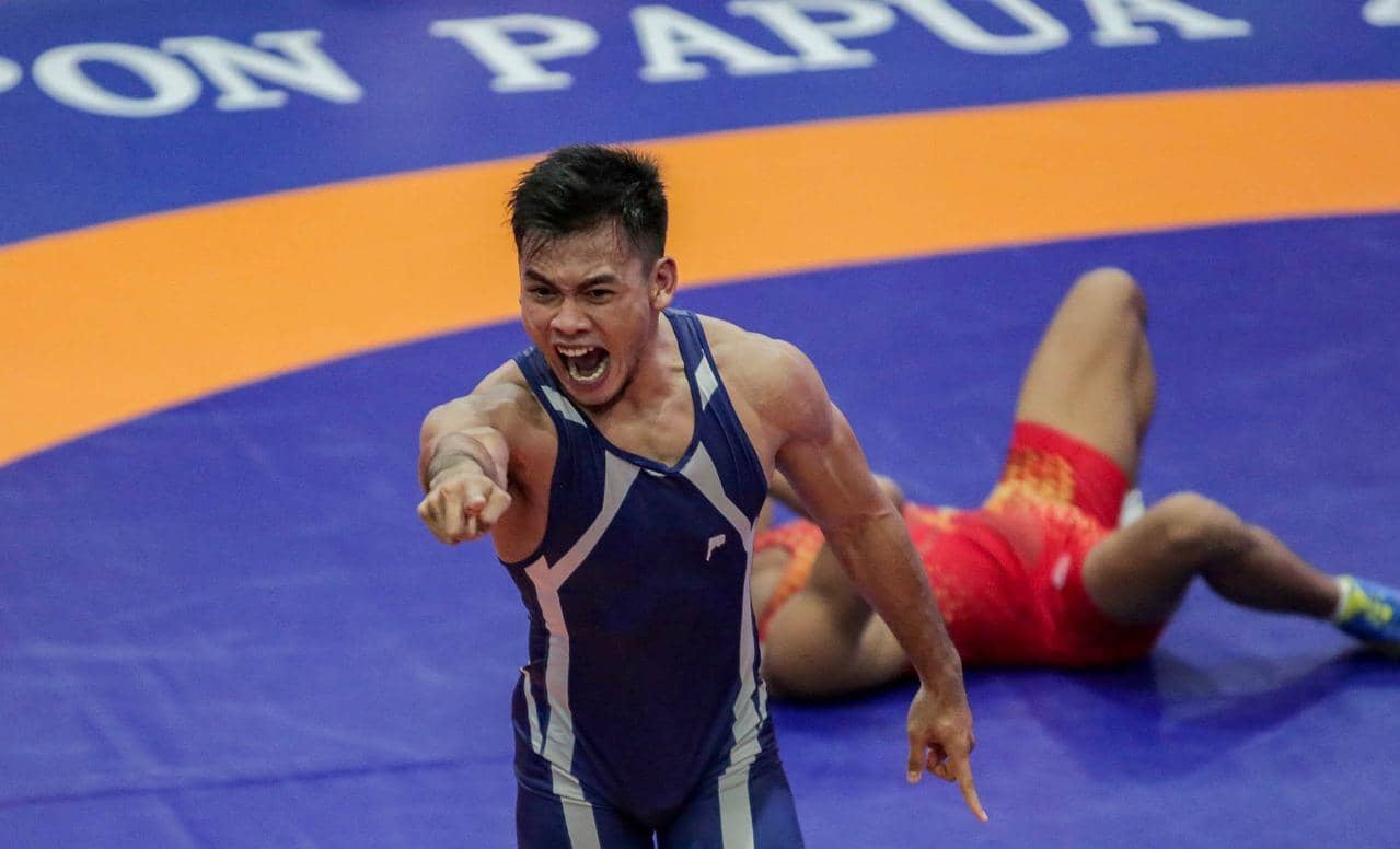 Ekspresi kemenangan pegulat DKI Jakarta, Andika Sulaeman usai mengalahkan lawannya, Supriono (Pegulat Jatim) di final kelas 77 kg gaya Greco Roman putra. (Foto: Humas PB PON/Lutfi).