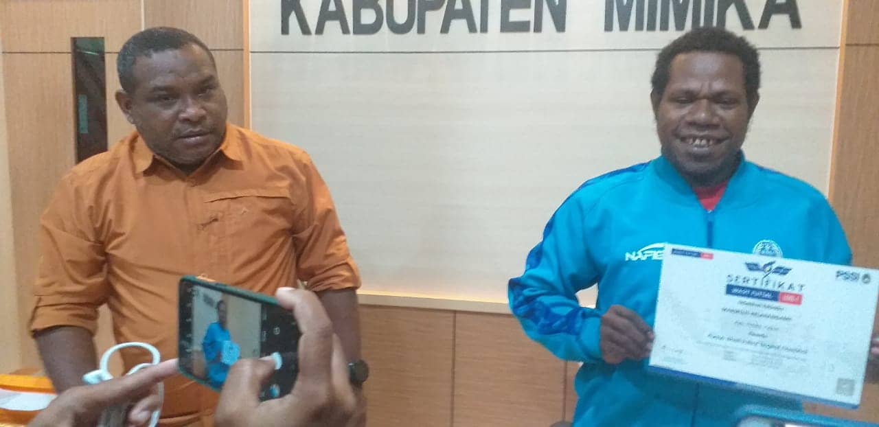 Marselus Kelanangame (kanan) saat menunjuk sertifikat wasit nasional.