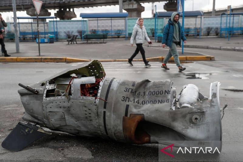 Orang-orang berjalan melewati sisa-sisa rudal di terminal bus saat invasi Rusia ke Ukraina berlanjut, di Kiev, Ukraina, Jumat (4/3/2022).