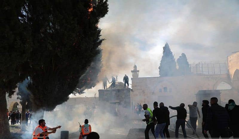 CjkinzN007008aPara petugas memadamkan kobaran api saat bentrokan terjadi antara pasukan keamanan Israel dan warga Palestina di kompleks Masjid Al Aqsa di Yerusalem Timur (22/4/2022). 20220423 CBMFN0A001 1 1 1