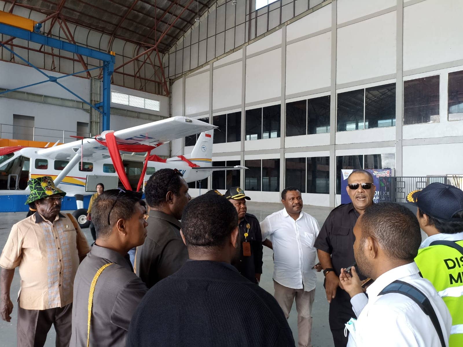 Foto: Febri Sekretaris Komisi C DPRD Mimika, Saleh Alhamid bersama anggota rombongan saat berada di hanggar dengan latar pesawat Cessna Grand Caravan PK-LTV milik Pemda Kabupaten Mimika.