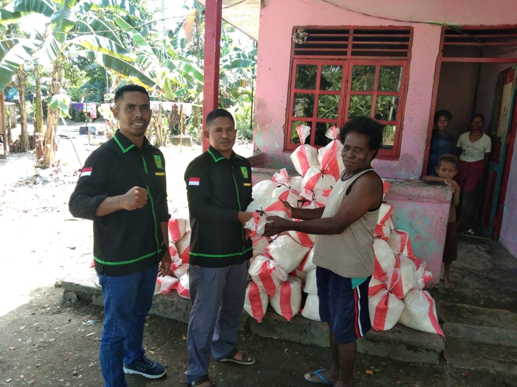 Ketua GPII Kabupaten Mimika Junaedi Boiratan sedang menyerahkan bantuan sagu kepada warga.