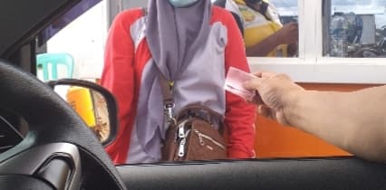 Seorang pengendara menerima karcis yang diberikan petugas penjaga portal Pasar Sentral Timika saat percobaan beberapa bulan lalu.