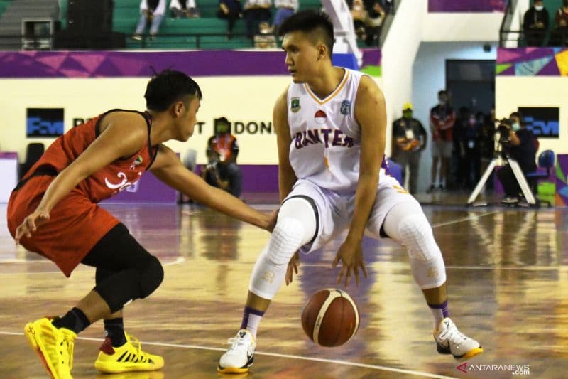 Pebasket putra Banten Agassi Yeshe (kanan) berusaha melewati pebasket putra Jawa Tengah Muh ukhlisin (kiri) pada pertandingan babak penyisihan basket putra 5x5 PON Papua di GOR Sport Centre, Timika, Kabupaten Mimika, Papua, Minggu (3/10/2021)