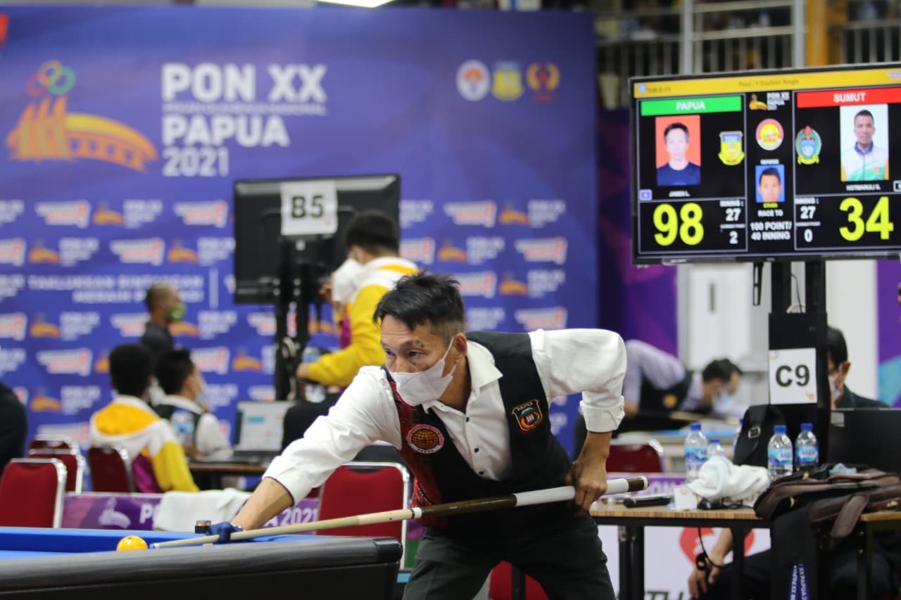 Pebiliar Papua James Lengkang mengalahkan pebiliar Sumatera Utara Hotmaruli Simarmata di partai final Cushion Single dengan skor telak 100-37, berlangsung di Venue Billiar Mimika, Selasa (5/10/2021). James adalah peraih empat medali emas atau menyapu bersih divisi caroom PON Jabar 2016./ Foto: Humas PPM PB PON XX / SEVIANTO PAKIDING