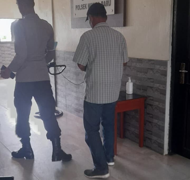 UN saat digiring oleh petugas Polsek Mimika Baru menuju ruang tahanan.