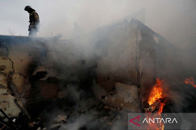 Pemadam kebakaran memadamkan api di sebuah rumah yang terbakar setelah serangan terbaru, di wilayah yang dikuasai separatis Donetsk, Ukraina, Snein (28/2/2022).