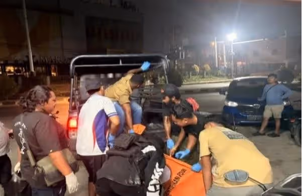 Polisi saat mengevakuasi jenazah korban.