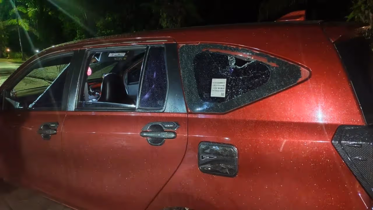 Toyota Calya yang diduga digunakan sebagai taksi online Maxim menjadi sasaran pelemparan batu di Jalan Poros Kwamki Narama, Mile 32