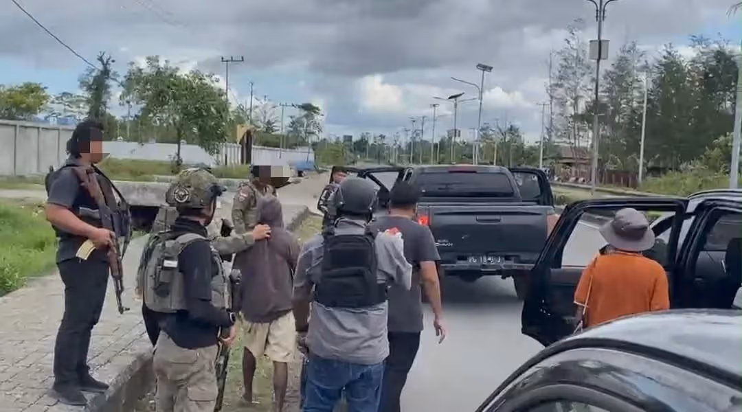 Personel gabungan mengamankan R.M. dan D.M. di Jalan Jenderal Sudirman, Kota Dekai, Yahukimo, dalam pengembangan kasus pembunuhan Bripka Anumerta Fredy Lukas Awes, Rabu (19/8/2026).