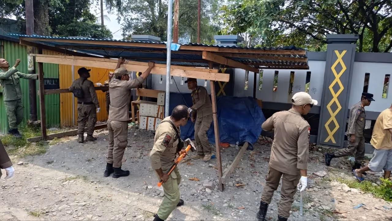 Satpol PP Mimika saat melakukan penertiban di depan pagar SMP Negeri 2, Jalan Budi Utomo Timika, Rabu (26/8).