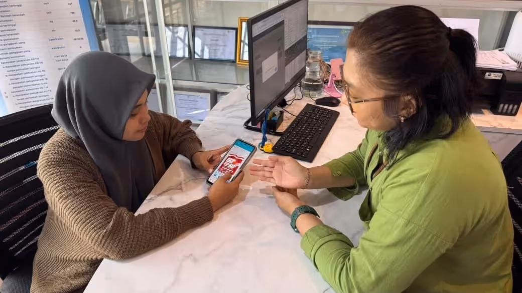 Pegawai PLN memberikan pendampingan kepada pelanggan dalam memanfaatkan promo “Merdeka Daya” melalui aplikasi PLN Mobile untuk mendapatkan diskon tambah daya listrik 50%.