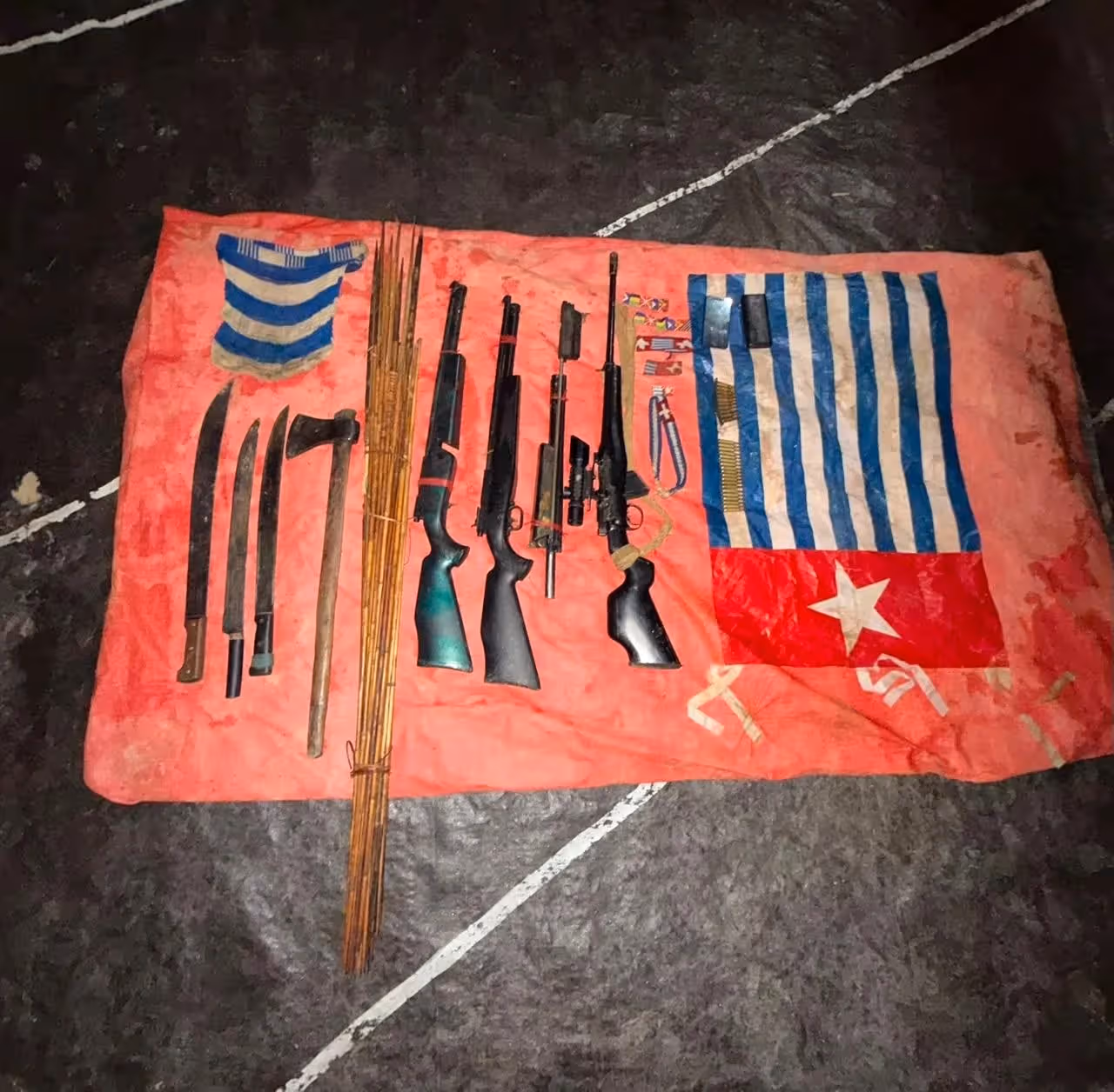 Nampak barang bukti berupa senjata api, senjata rakitan serta bintang kejora yang berhasil disita dari honai transit OPM pimpinan Daniel Aibon.
