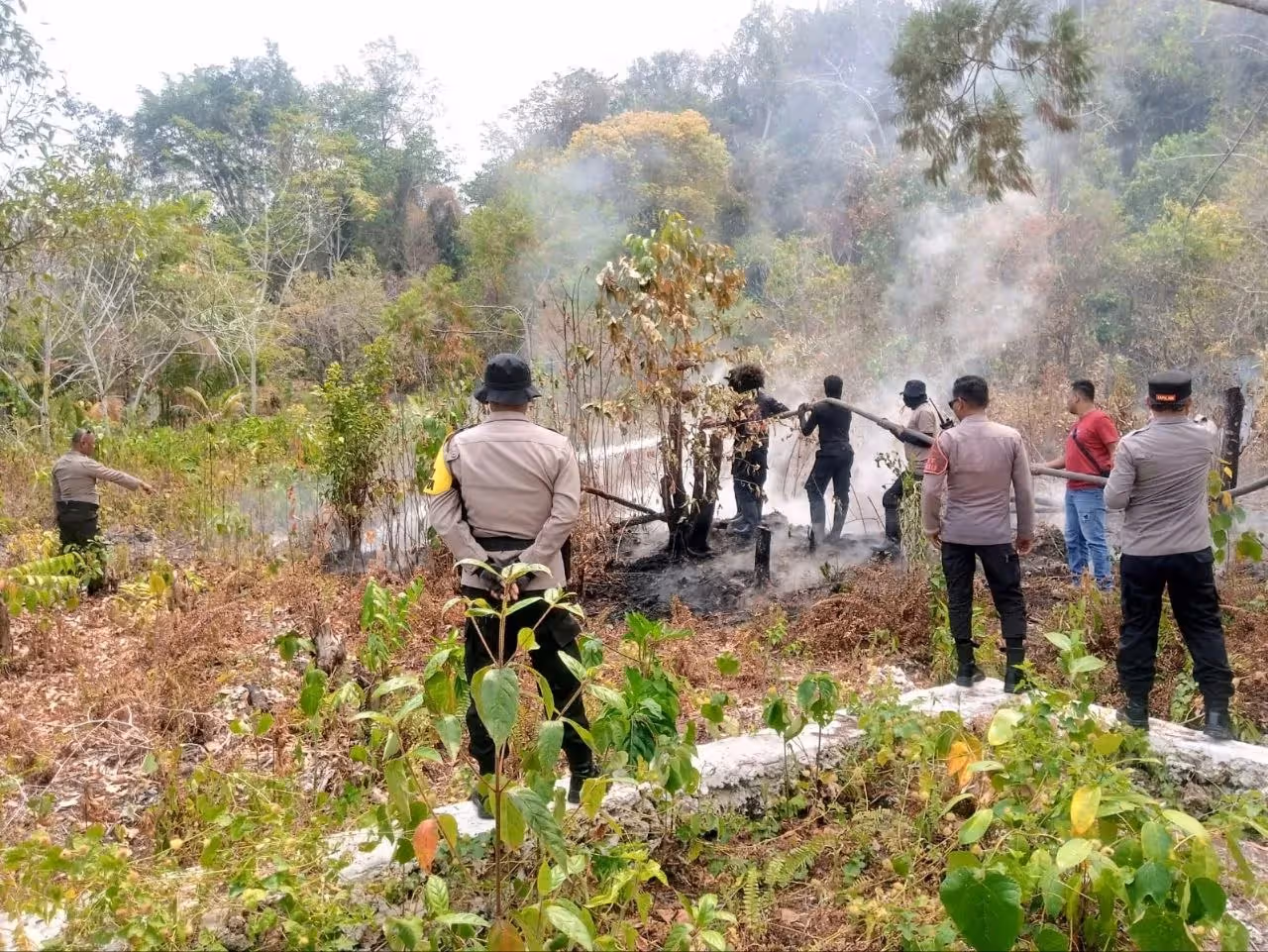 Polisi saat membantu memadamkan kebakaran hutan dan lahan