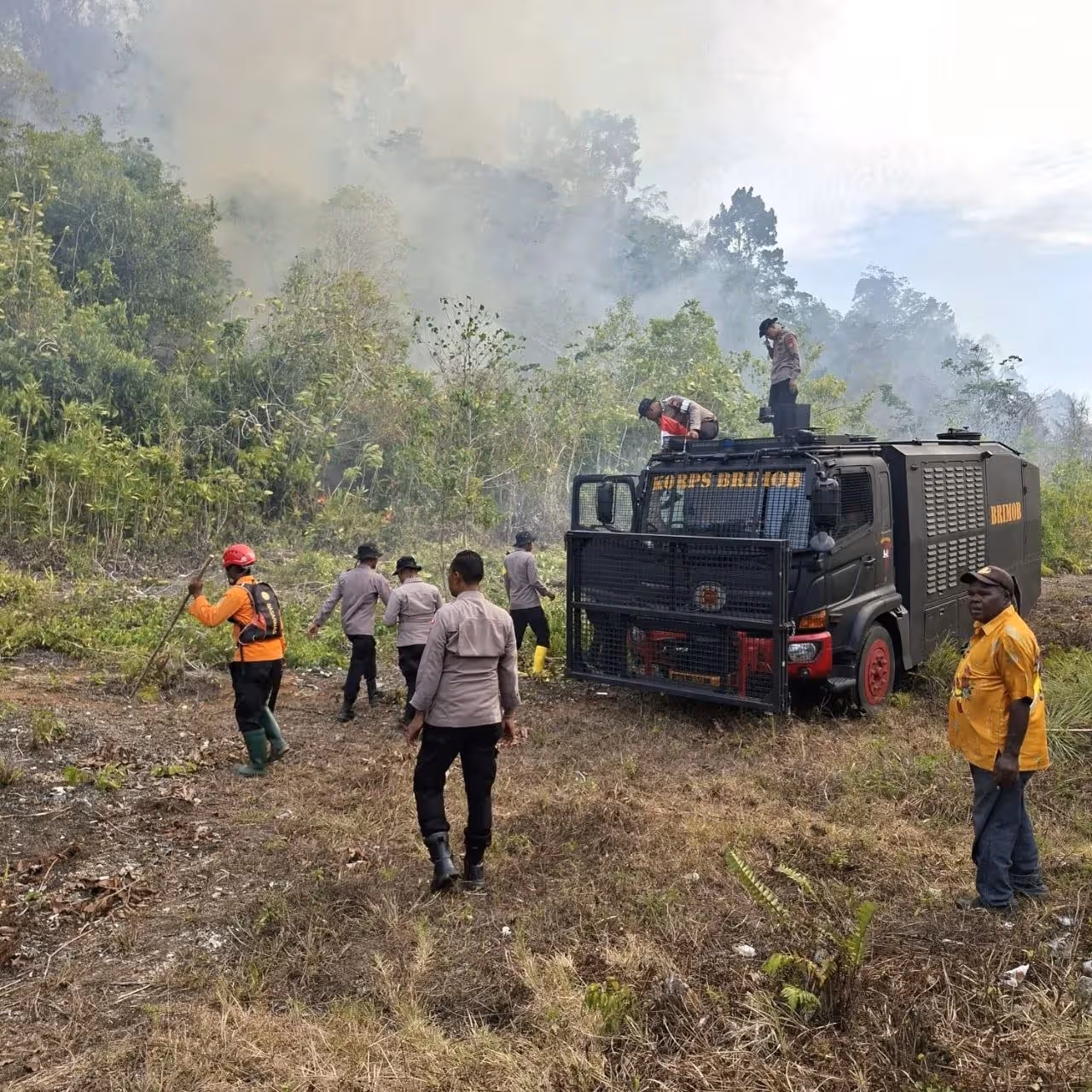 Polisi saat membantu menangani kebakaran hutan di Biak