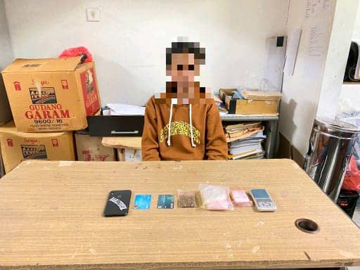 Salah seorang tersangka bersama barang bukti narkotika