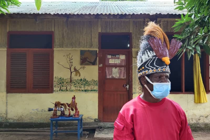 Pengerajin replika cenderawasih, Daniel Tanoy, menggunakan topi dengan replika burung cenderawaih yang dia buat dari sabut dan daun kelapa