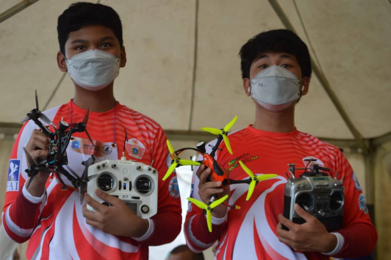 KETERANGAN FOTO 1.Atlet Aeromodelling Radio Control Racing DKI jakarta , Ezra (kiri) dan Axel( kanan) saat berfoto memamerkan drone miliknya usai pertandingan di venue Aeromodelling SP-1, Timika, Stadion Wania, Kamis(7/10/2021). Foto:Lukas tandilimbong.