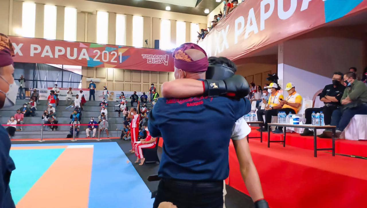 Foto : Humas PPM/Hasan Sainus 1. Atlet Bali memeluk pelatihnya sambil menangis gembira karena kemenangan TKO atas atlet asal Sumatra Utara pada Final Cabor Tarung Derajat di Venue Eme Neme Yauware, Timika, Selasa (12/10)