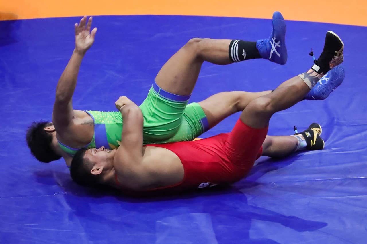 Aksi pegulat Kaltim, Ashar Ramadhan (merah) saat melakukan bantingan pada pegulat Jatim, Agus Fajar (hijau) dan berhasil menang di final. (Foto: Humas PB PON/Billy).