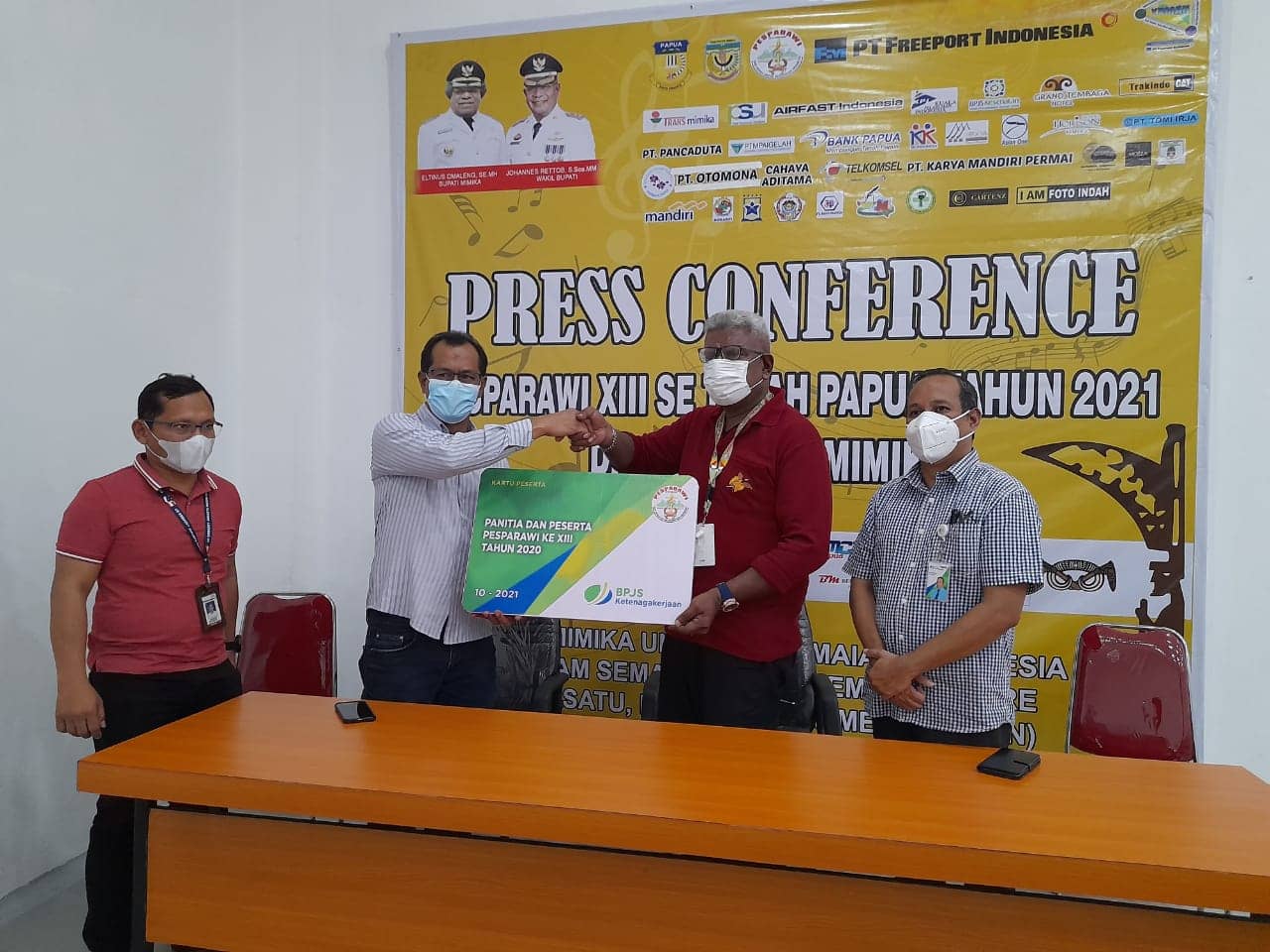 Direktur SDM PT KPI, Arony Faruwu menyerahkan kartu peserta BPJAMSOSTEK kepada Ketua Umum Panitia Pesparawi, Johannes Rettob, SSos MM didampingi Kepala BPJS Ketenagakerjaan Cabang Mimika, Verry Boekan. Foto: Selvi/Pesparawi XIII