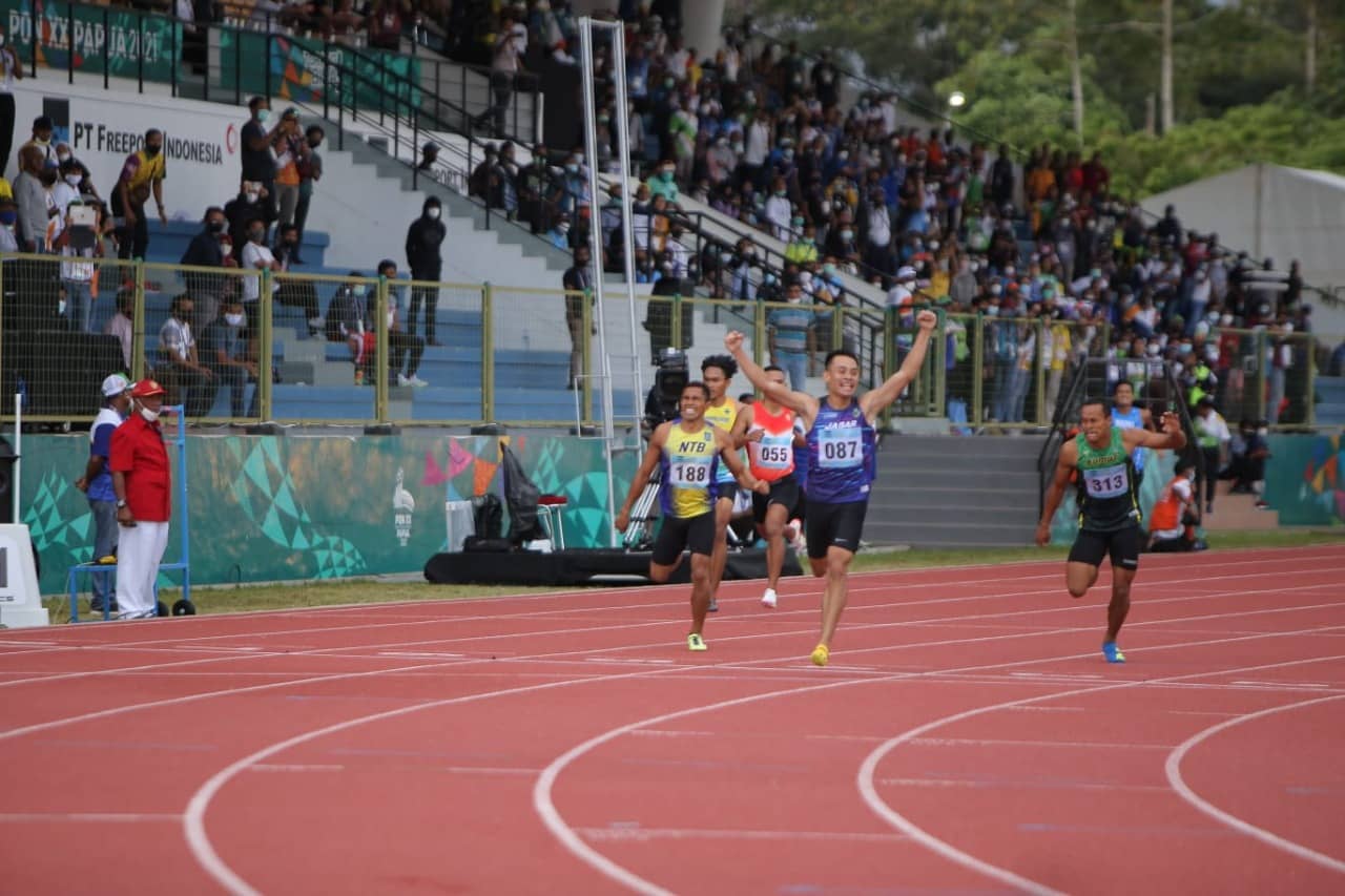 KETERANGAN FOTO : 1.Atlet Jawa Barat (Jabar) Halomoan Edwin B Simanjuntak berhasil menyabet medali emas dan memecahkan rekor PON pada nomor lari 400 meter gawang putra dengan catatan waktu 51,32 detik arena atletik Mimika Sport Complex, Minggu (10/10/2021). Foto: Humas PPM/ David La'lang.