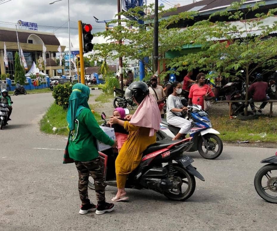 Seorang ibu sedang memberi sumbangan kepada pengurus KKJB yang berada di lampu merah.