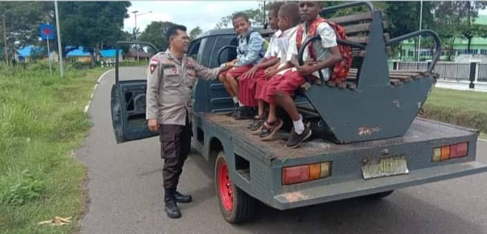 Nampak personil Polsek Sota, Merauke saat mengatur siswa SD yang hendak diantar ke sekolah.