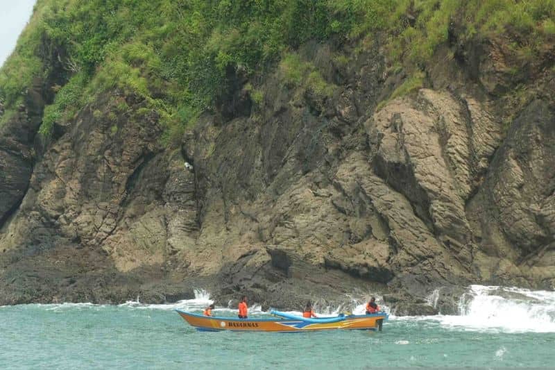 Tim SAR melakukan pencarian korban yang terseret ombak dengan menggunakan perahu di perairan Pantai Payangan Jember, Jawa Timur, Minggu (13/2/2022)