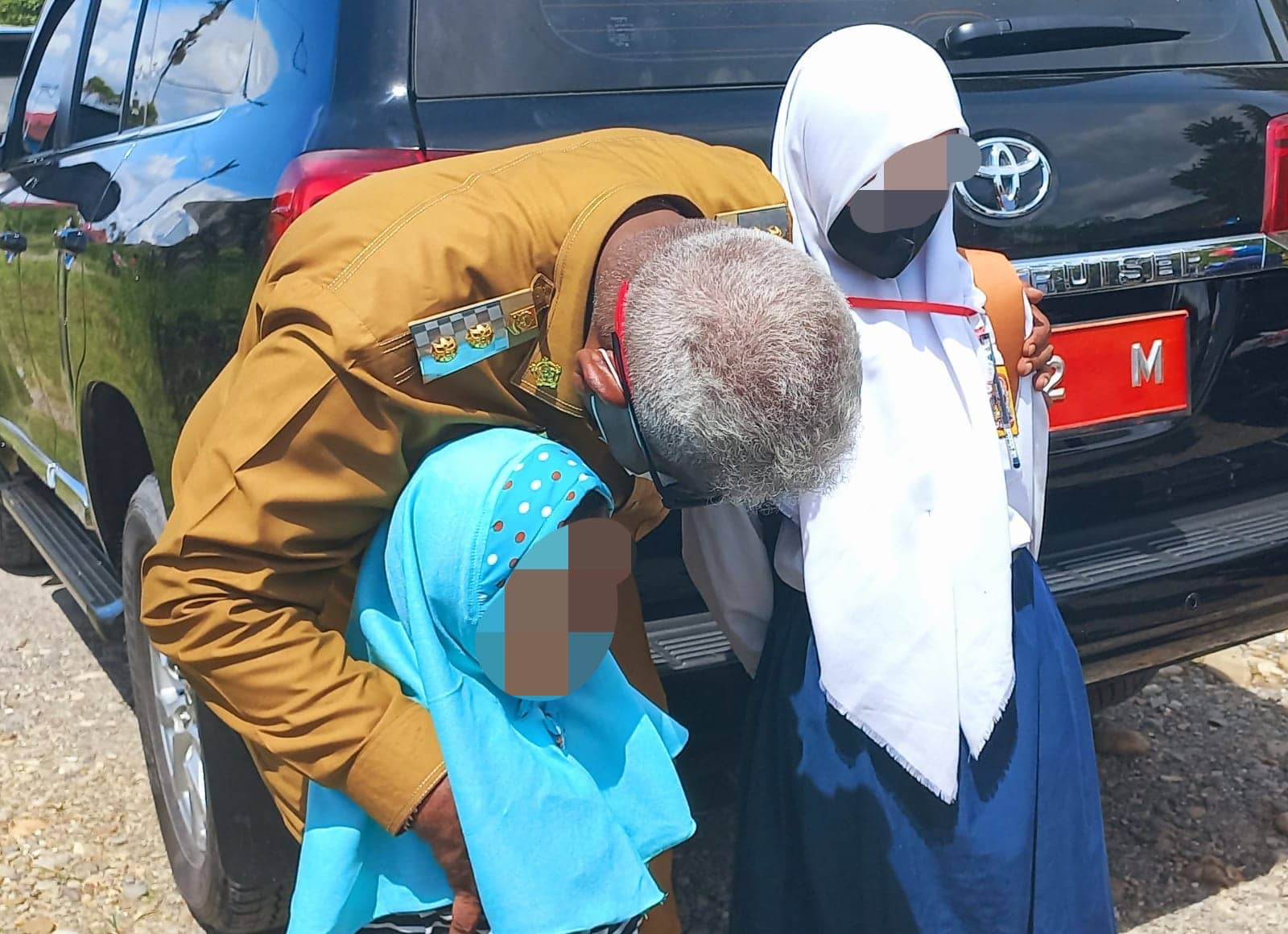 Wabup Johannes Rettob membisikan ke telinga Nisa, saat mengantar sumbangan untuk kedua gadis yatim piatu itu di SP 4.