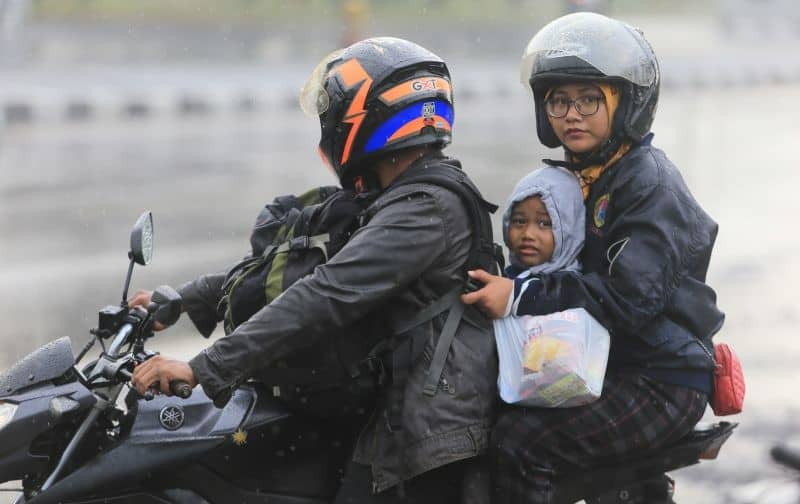 Pemudik menerobos hujan saat melintas di jalur Pantura, Widasari, Indramayu, Jawa Barat, Rabu (27/4/2022)