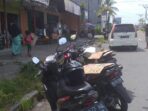 Para bocah jasa penutup motor menggunakan karton di jalan Yos Sudarso Timika