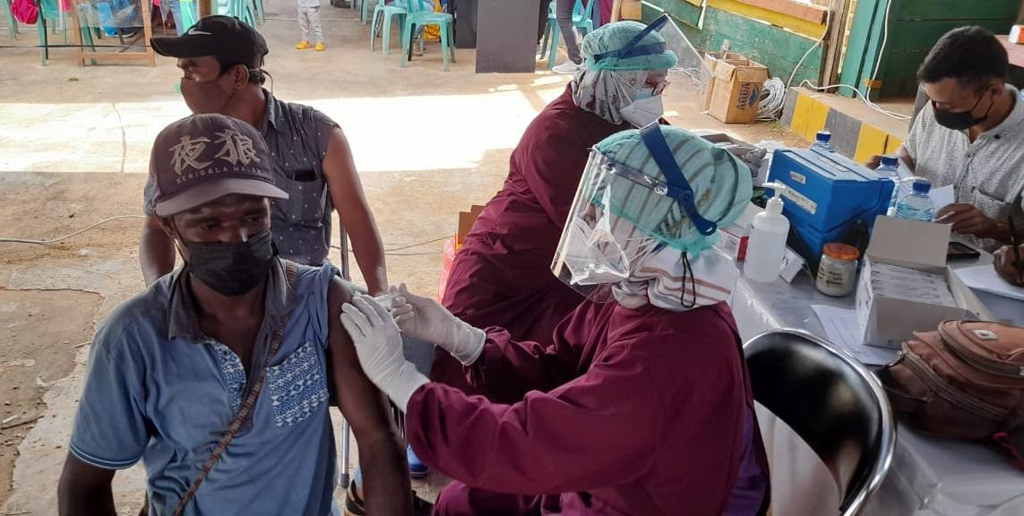 Warga asli Papua diberi vaksin oleh petugas medis