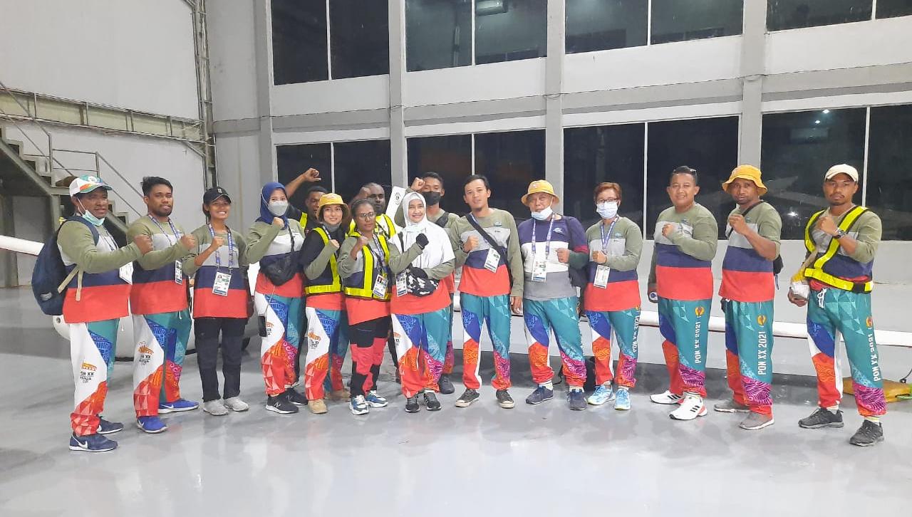 Penyumbang medali emas Andi Abdul Rohman (keenam dari kanan) foto bersama tim Papua di Hanggar Bandar Udara Internasional Mozes Kilangin Timika Sisi Selatan, Rabu malam (29/9/2021). Foto : Yosefina Dai Dore
