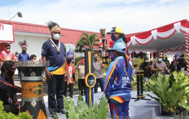 Bupati Biak Numfor Herry Ario Naap menerima api PON XX Papua dari mantan atlet nasional angkat besi Lisa Rumbewas saat tiba di kantor bupati Kabupaten Biak Numfor, Senin (27/9).