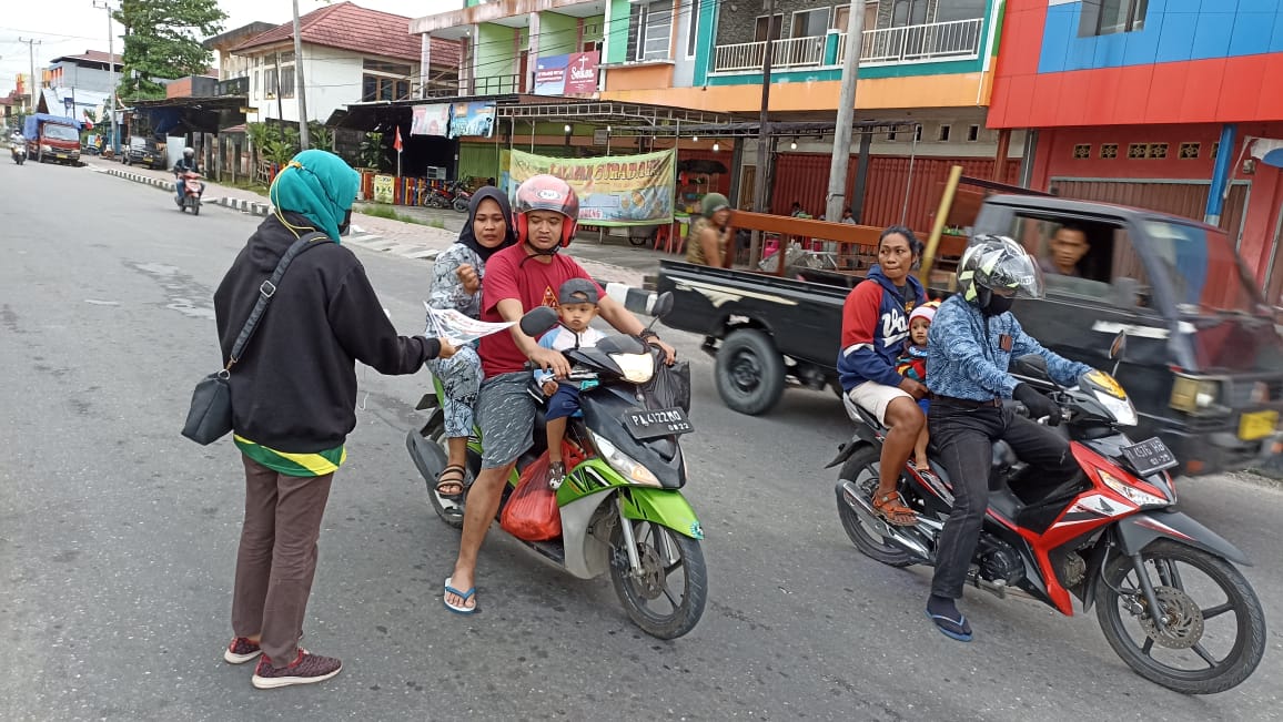 SALAH seorang anggota OKP Cipayung saat membagikan brosur dan pamflet sosialisasi PON XX Papua di traffic light Timika Mall.