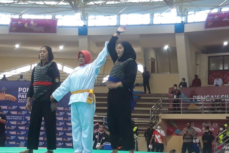 Atlet silat Provinsi Sumatera Utara Rizka Andini (biru) yang merupakan juara dunia sekaligus peraih medali perunggu pada PON XIX Jawa Barat berhasil menyingkirkan Rinindah IIN L (merah) pesilat tuan rumah cabang olahraga pencak silat PON XX GOR Toware Kabupaten Jayapura, Sabtu.
